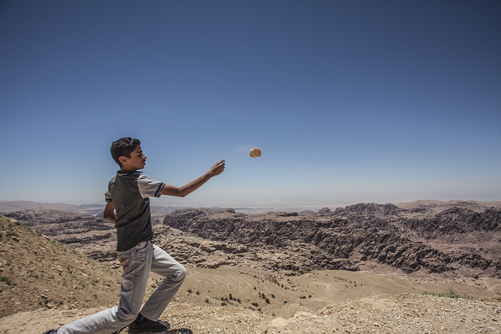 Bambino gioca a lanciare i sassi nella valle dell'Edom. Courtesy of Carlos Solito